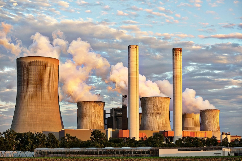 Image of a factory emitting smoke into the environment symbolizing carbon emissions.