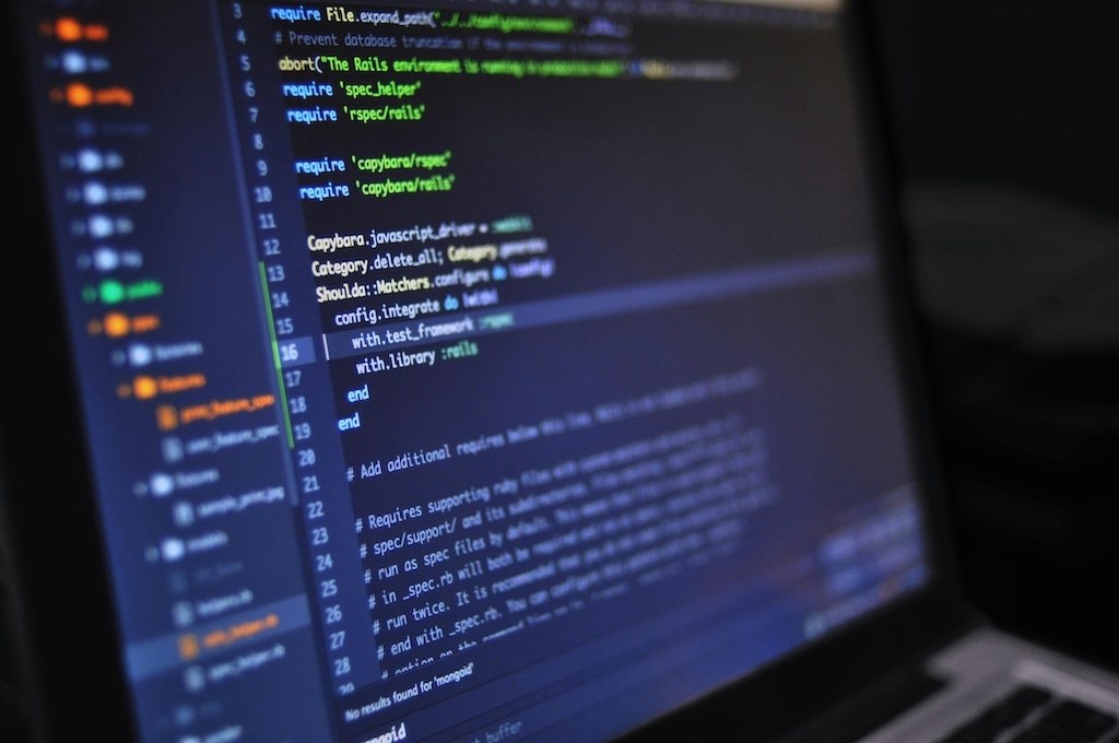 Image of a dark screen displaying colorful code.