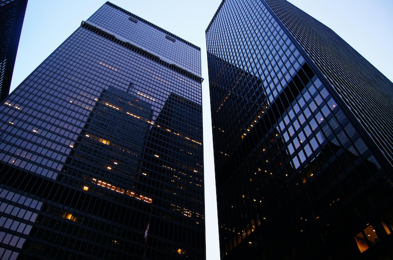 A shot of two corporate skyscrapers taken from ground level to create a towering and impressive view.