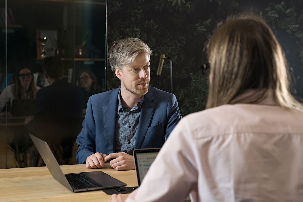 A software security consultant discussing software development risks with a client after doing a thorough analysis of their entire software portfolio with Sigrid, the all-in-one software excellence platform.