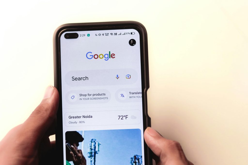 Image of a phone displaying a google search bar with image search and voice recognition.