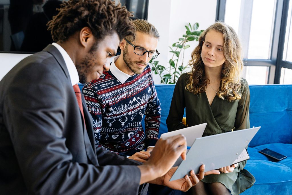 Image of 3 colleagues in an office setting have a meeting