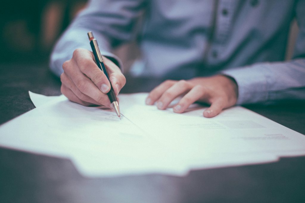 Person looking through some legal documents and signing them